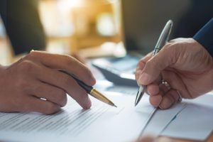 Befristeter Arbeitsvertrag, zwei Personen unterschreiben einen Vertag